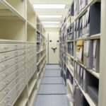 gray archival boxes on mobile shelving system
